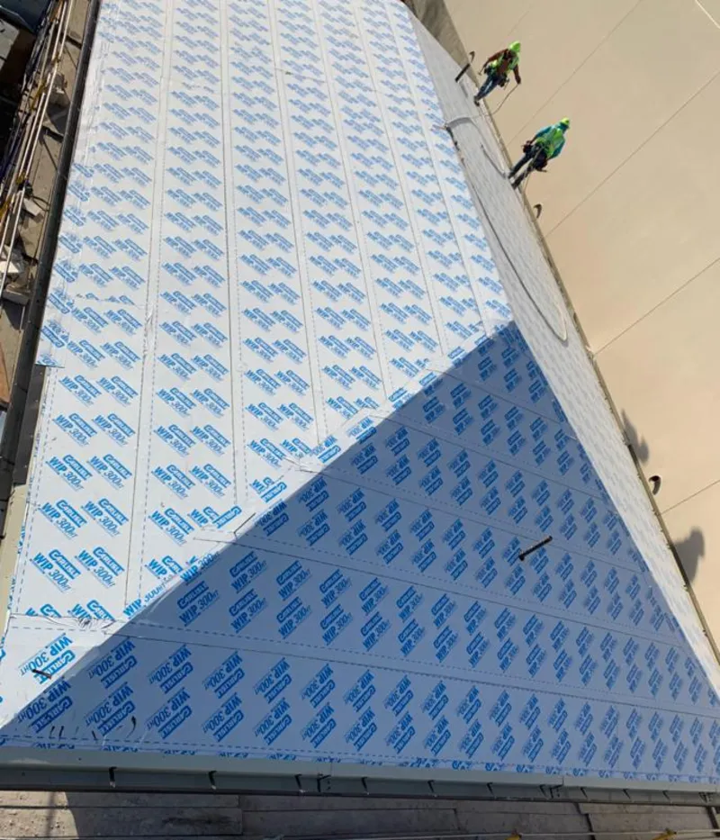 Professional roofers installing underlayment on a metal roof in West Sacramento